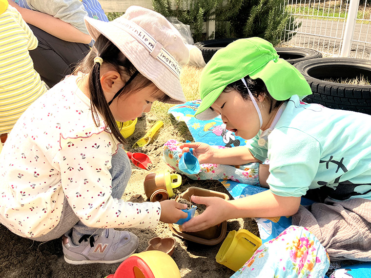 砂場で遊んでるこども達